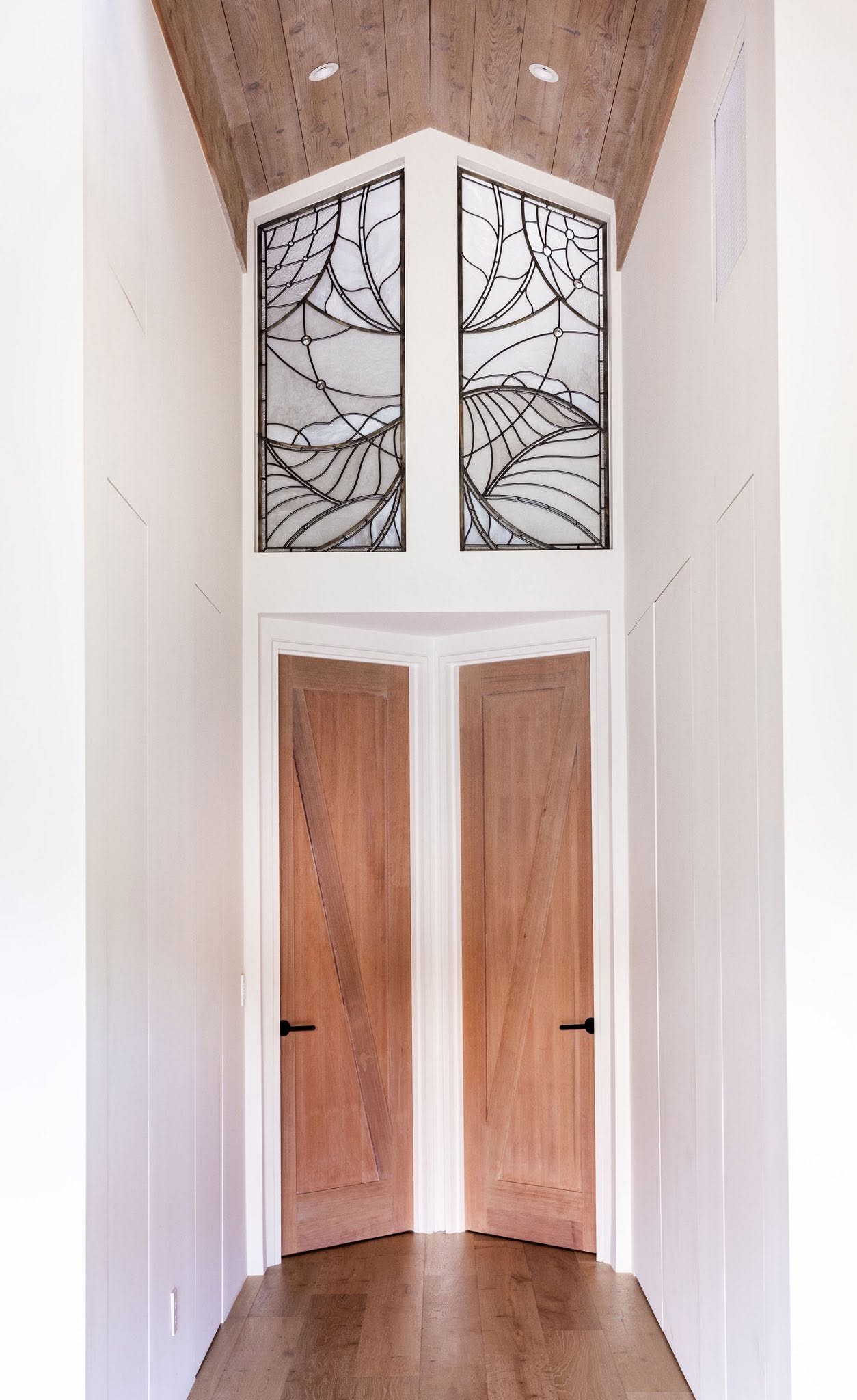Entry alcove with wood doors and decorative glass